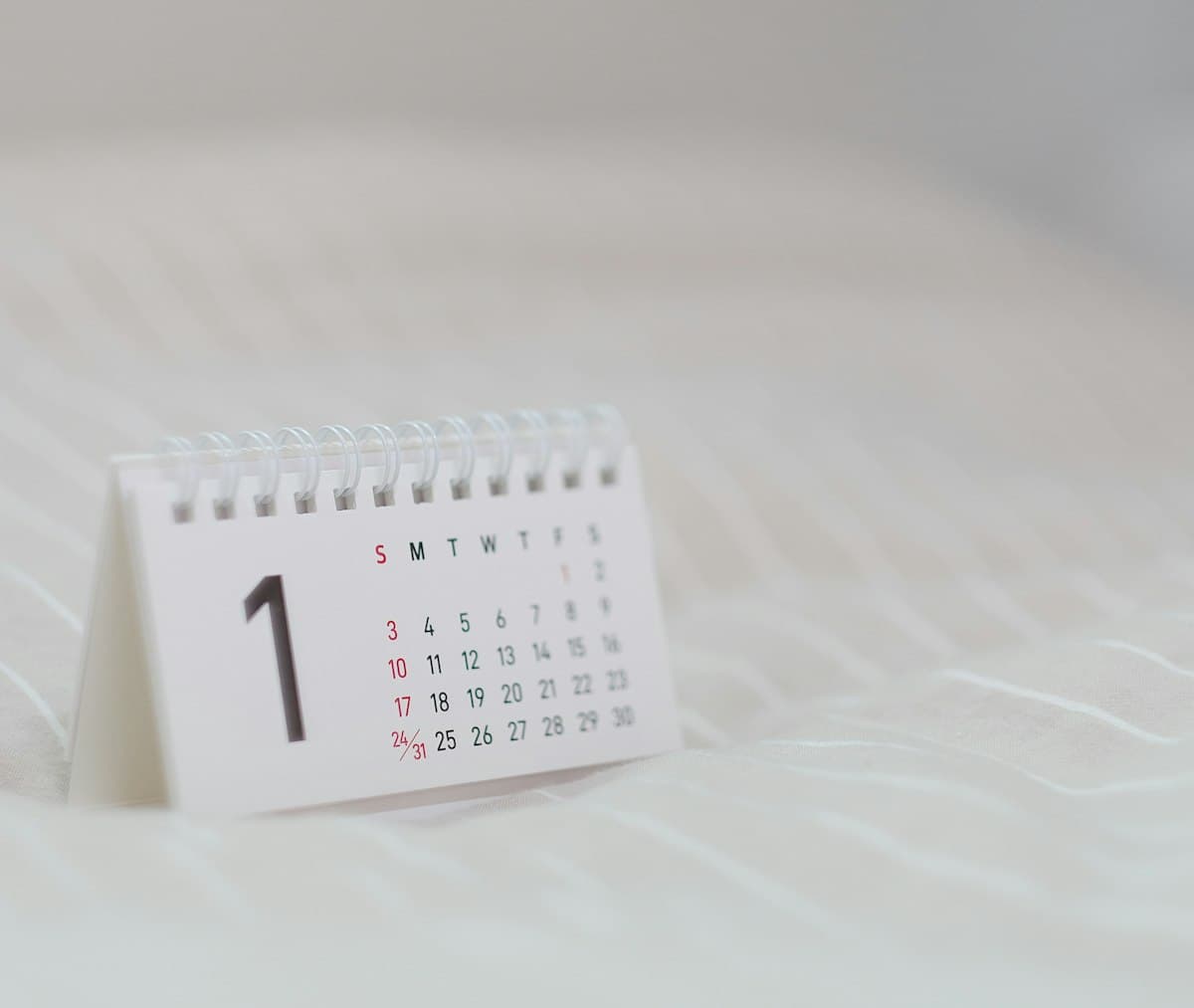 White wall calendar hanging on a plain background, used to count birthdays and years