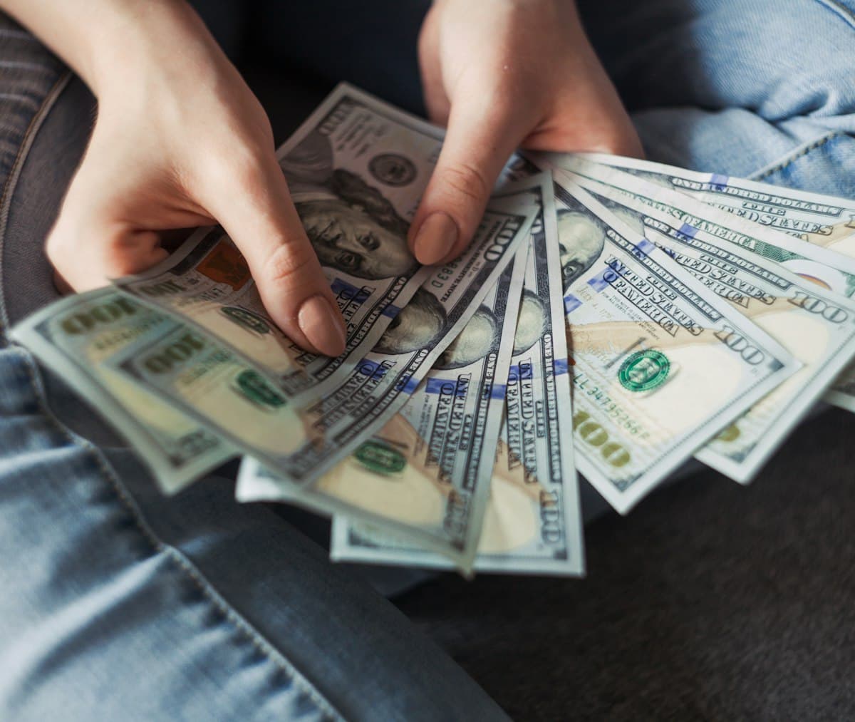 Fan of 100 US dollar banknotes representing borrowed money and loan repayments