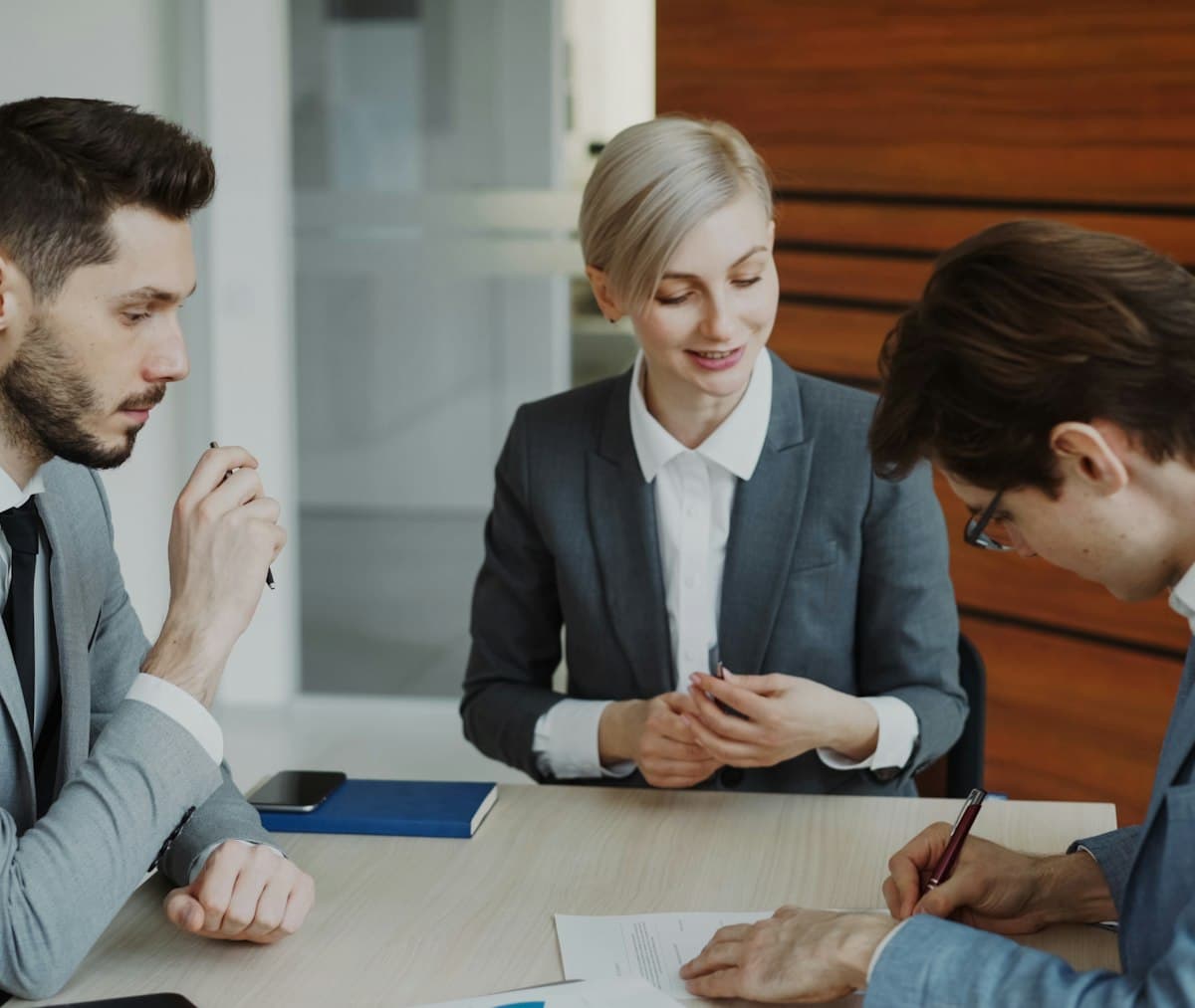Business people signing a loan contract at a table after agreeing the repayment terms